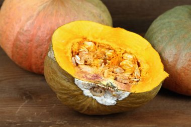 Ahşap tahta üzerinde yarısı çürük kabak ve sağlıklı kabaklar arka kesim