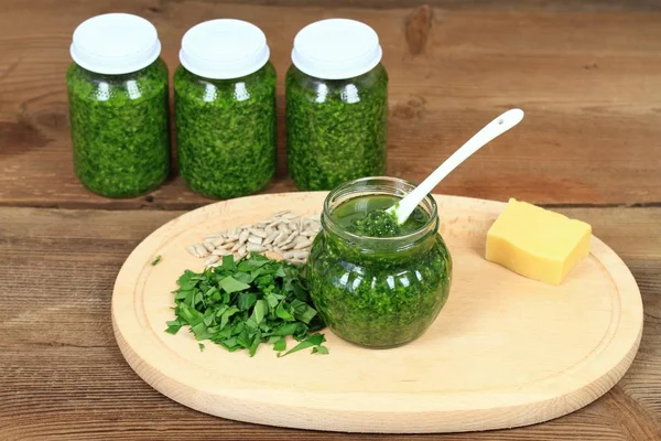 Homemade pesto in jars on rustic wooden table — Stock Photo, Image