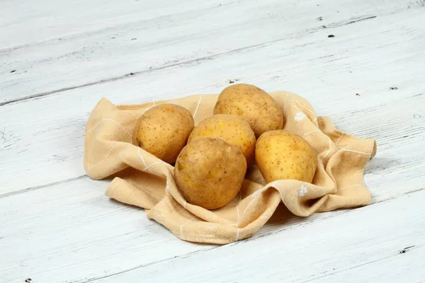 Raw potatoes on the white table — Stock Photo, Image