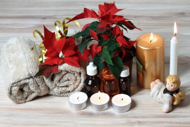 Noel spa konseptiyle mumlar ve kırmızı Noel çiçek Atatürk çiçeği