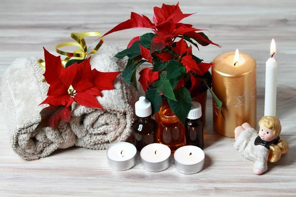 Christmas spa concept with candles and red Christmas flower poinsettia. — Stock Photo, Image