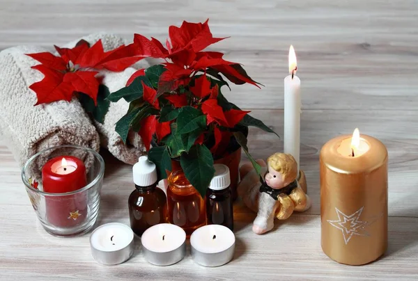 Christmas spa concept with candles and red Christmas flower poinsettia — Stock Photo, Image
