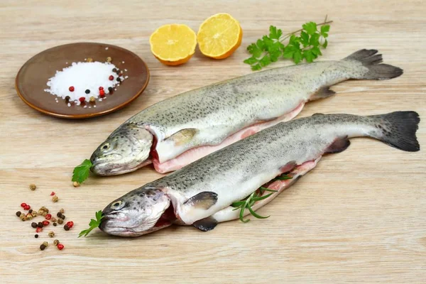 Świeży pstrąg surowe ryby z przyprawami do gotowania na drewnianym stole — Zdjęcie stockowe
