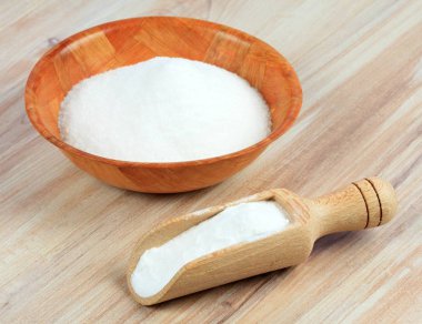 Karbonat (sodyum bikarbonat). Kola kaşıkta, kase de tahta masada.