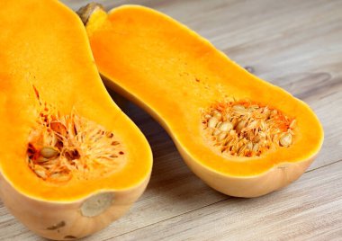 Balkabağı Tereyağlı Liscia ikiye bölündü. Tahta masada sarı lezzetli balkabağı.