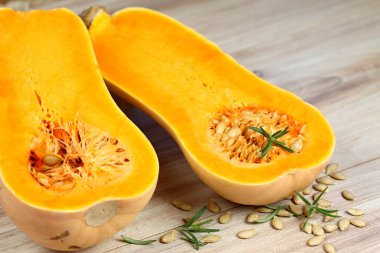 Balkabağı Tereyağlı Liscia ikiye bölündü. Tahta masada sarı lezzetli balkabağı.