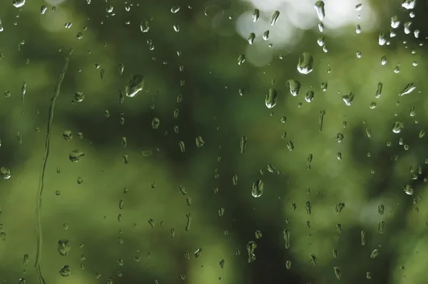 多雨的夏季的一天，在明亮的卧式湿的窗户玻璃上的雨滴抽象雨水背景图案详图，宏特写，详细的绿、 蓝、 黑生动的灰色水滴，温柔的散景，洪降雨季节概念 — 图库照片