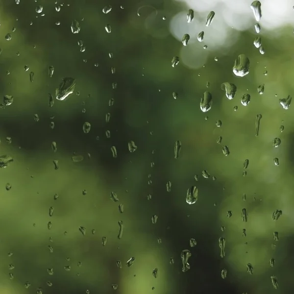 Giornata estiva piovosa, gocce di pioggia sul vetro della finestra bagnata, dettagli astratti luminosi del motivo dell'acqua piovana, primo piano macro, dettagliate gocce d'acqua verdi, blu, grigio scuro vivido, bokeh delicato, concetto di stagione delle piogge pluviale — Foto Stock