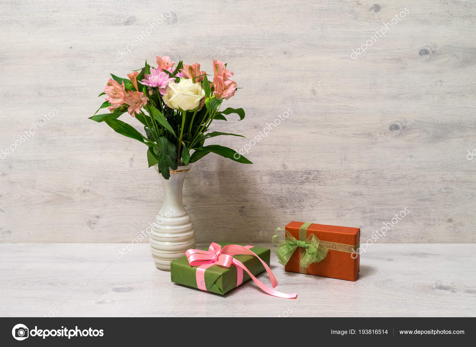 木製の背景にギフト ボックスと花瓶のバラ アルストロメリアの花のカラフルな春のブーケ ストック写真 C Atanechkav