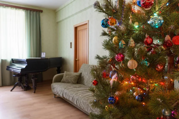 Piękna Świąteczna ozdobione choinki w wnętrz pokój dzienny z sofą, fortepian i okna. Koncepcja nowego roku wakacje w przytulnym domu — Zdjęcie stockowe