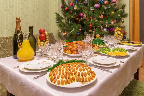 リビング ルームのインテリアで美しく飾られたクリスマス ツリーの近くお祝い料理提供テーブル。居心地の良い家で年始のコンセプト — ストック写真