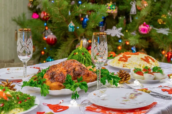 Feestelijke kerst geserveerd tafel tegen mooie groene dennenboom versierd met vele kleurrijke nieuwjaar speelgoed. Kerstdiner, heerlijk eten, kerstkalkoen. Wintervakantie viering in gezellig huis — Stockfoto