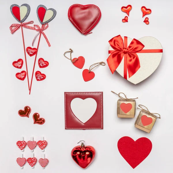 Verschiedene Herzen und stilvolle Accessoires in Herzform, Geschenke und Süßigkeiten in roter Farbe auf weißem Hintergrund. Leerer Fotorahmen, Attrappe auf. Grußkarte zum Valentinstag, Liebes- und Romantikkonzept — Stockfoto