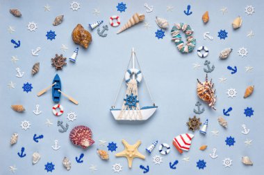 Dekoratif eşyalar ve minyatür oyuncaklardan oluşan yuvarlak çerçeve: deniz kabukları, seastarlar, tekne, çapalar, direksiyon simidi, can simidi. Geminin yaratıcı bileşimi. Yaz tatili, deniz yolculuğu konsepti.