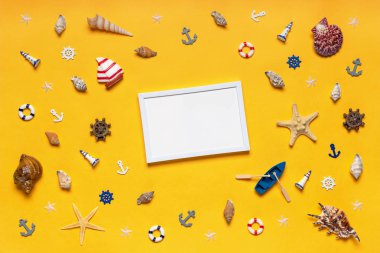 Dekoratif eşyalar ve minyatür oyuncaklardan oluşan yuvarlak çerçeve: deniz kabukları, seastarlar, tekne, çapalar, direksiyon simidi, can simidi. Boş beyaz fotofram, maket. Yaz tatili, deniz yolculuğu konsepti.