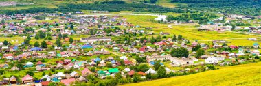 Yaz bulutlu bir günde panoramik manzara ve küçük bir kasaba. Bir sürü renkli evi olan pitoresk şehir manzarası. Sim, Chelyabinsk bölgesi, Rusya. Seyahat günlüğü kavramı