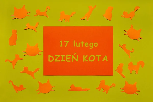 Feliz Día del Gato en Polonia. Siluetas de jengibre gato y caras divertidas, hoja de papel naranja sobre fondo verde claro. Disposición festiva para vacaciones felinas, texto en polaco 17 FEBRERO DÍA DEL CAT. Puesta plana — Foto de Stock