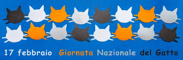 Feliz Día del Gato en Italia. Caras de gato graciosas negras, naranjas, grises y blancas sobre fondo azul. Disposición festiva para las vacaciones felinas, texto en italiano 17 FEBRERO DÍA NACIONAL DEL CAT. Colocación plana, vista superior, pancarta — Foto de Stock