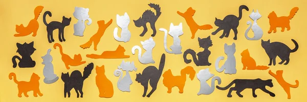 Happy World Cat Day. Black, grey and orange funny cat silhouettes on yellow pastel background. Festive layout or mock up for feline holiday or pet health concept. Flat lay, top view, banner — Stock Photo, Image