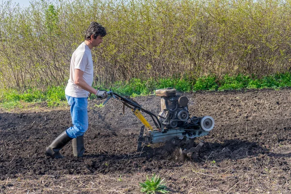 Man Wellingtons Met Cultivator Ploegen Grond Zonnige Dag Boer Ploegen — Stockfoto