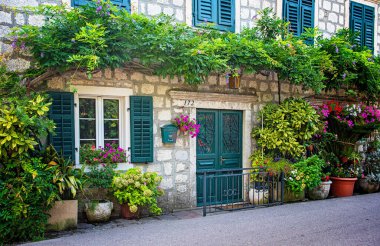 KOTOR, MONTENEGRO - 10 AĞUSTOS, 2019: Karadağ 'ın Kotor Körfezi' nde çiçekli geleneksel ev.
