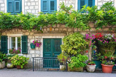 KOTOR, MONTENEGRO - 10 AĞUSTOS, 2019: Karadağ 'ın Kotor Körfezi' nde çiçekli geleneksel ev.