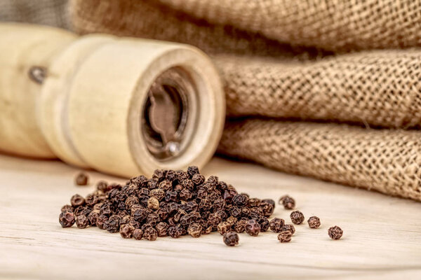 Деревянная перечная мельница и черный перец
