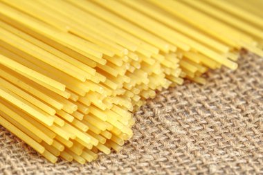 İtalyan spagetti closeup demet. Rustik bir arka plan üzerinde sarı uzun spagetti. 