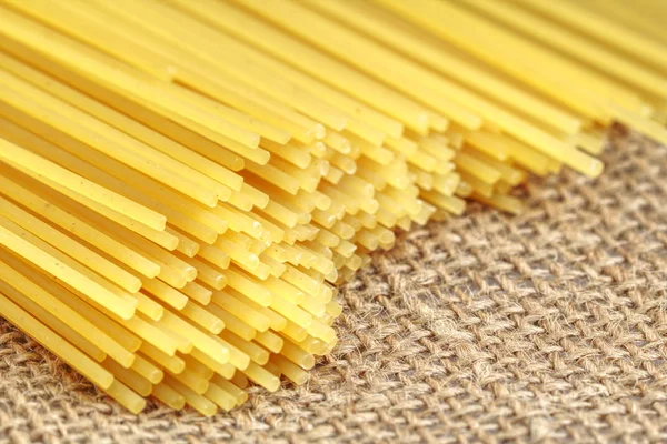 Un montón de espaguetis italianos de cerca. Espaguetis largos amarillos sobre un fondo rústico . —  Fotos de Stock