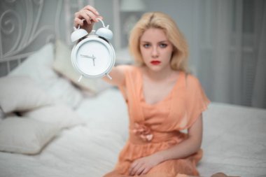Yorgun kız yatmak istiyor ve alarm ayarlar.