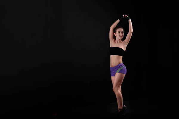 Sport ragazza tira le mani verso l'alto di sfondo nero . — Foto Stock