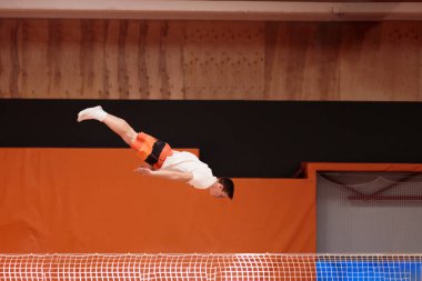 Zarif uçuş trambolin üzerinde genç atlet.