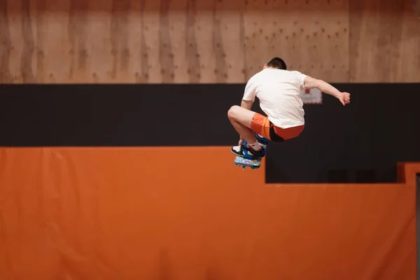 Jonge atleet op de trampoline in de sierlijke vlucht. — Stockfoto