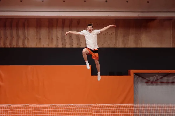 Jonge atleet op de trampoline in de sierlijke vlucht. — Stockfoto