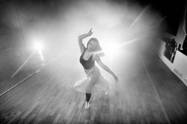 Güzel kız zarif duman ve sis içinde dans ediyor.