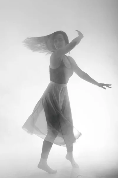 Bella ragazza danza elegantemente in fumo e nebbia . — Foto Stock