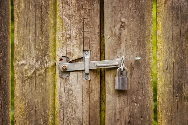 Wooden gate with hinge and padlock — Stock Photo, Image