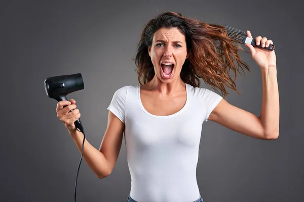 Mujer joven con un secador de pelo — Foto de Stock