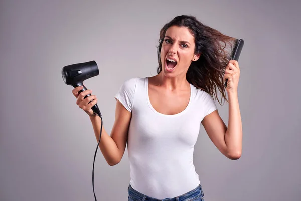 Mujer joven con un secador de pelo — Foto de Stock