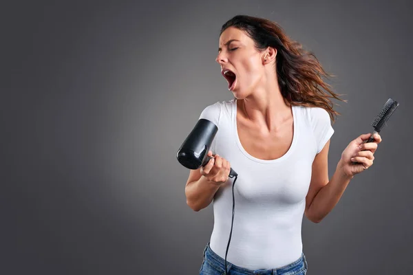 Jonge vrouw met een haardroger — Stockfoto