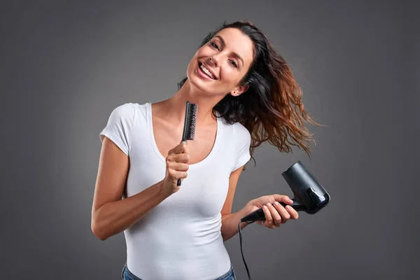 Young woman with a hairdryer — Stock Photo, Image