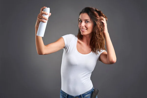 Mujer joven con un spray para el cabello —  Fotos de Stock