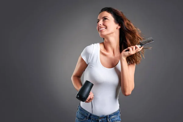 Young woman with hairdryer — Stock Photo, Image