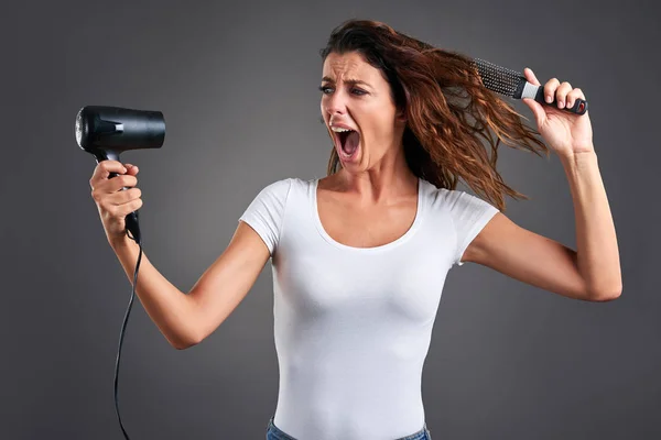 Mujer joven con un secador de pelo —  Fotos de Stock