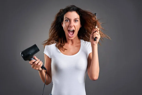 Jonge vrouw met een haardroger — Stockfoto