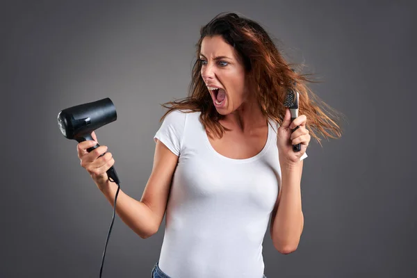 Young woman with a hairdryer — Stock Photo, Image