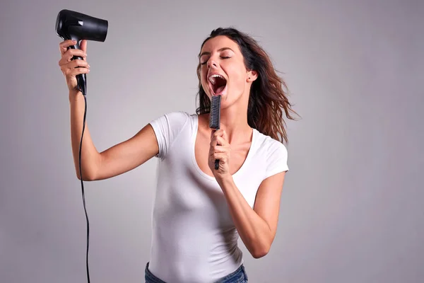 Jonge vrouw met een haardroger — Stockfoto