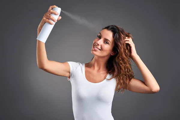 Mujer joven con un spray para el cabello —  Fotos de Stock