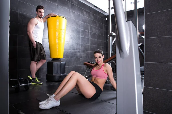 Pareja joven tomando un descanso en un gimnasio durante el entrenamiento —  Fotos de Stock