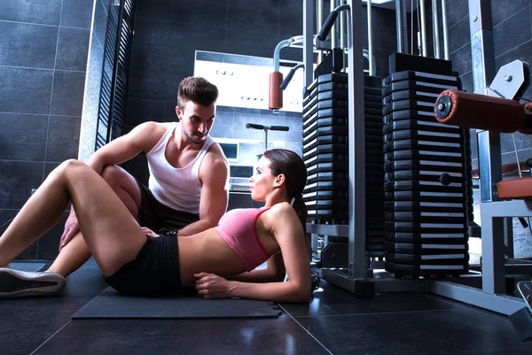 Mujer joven con su entrenador personal en el gimnasio —  Fotos de Stock